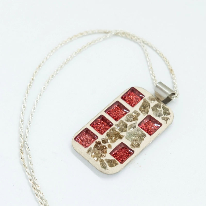 This pendant combines the bold allure of red with a luxurious touch of gold to add glamour to your wardrobe
