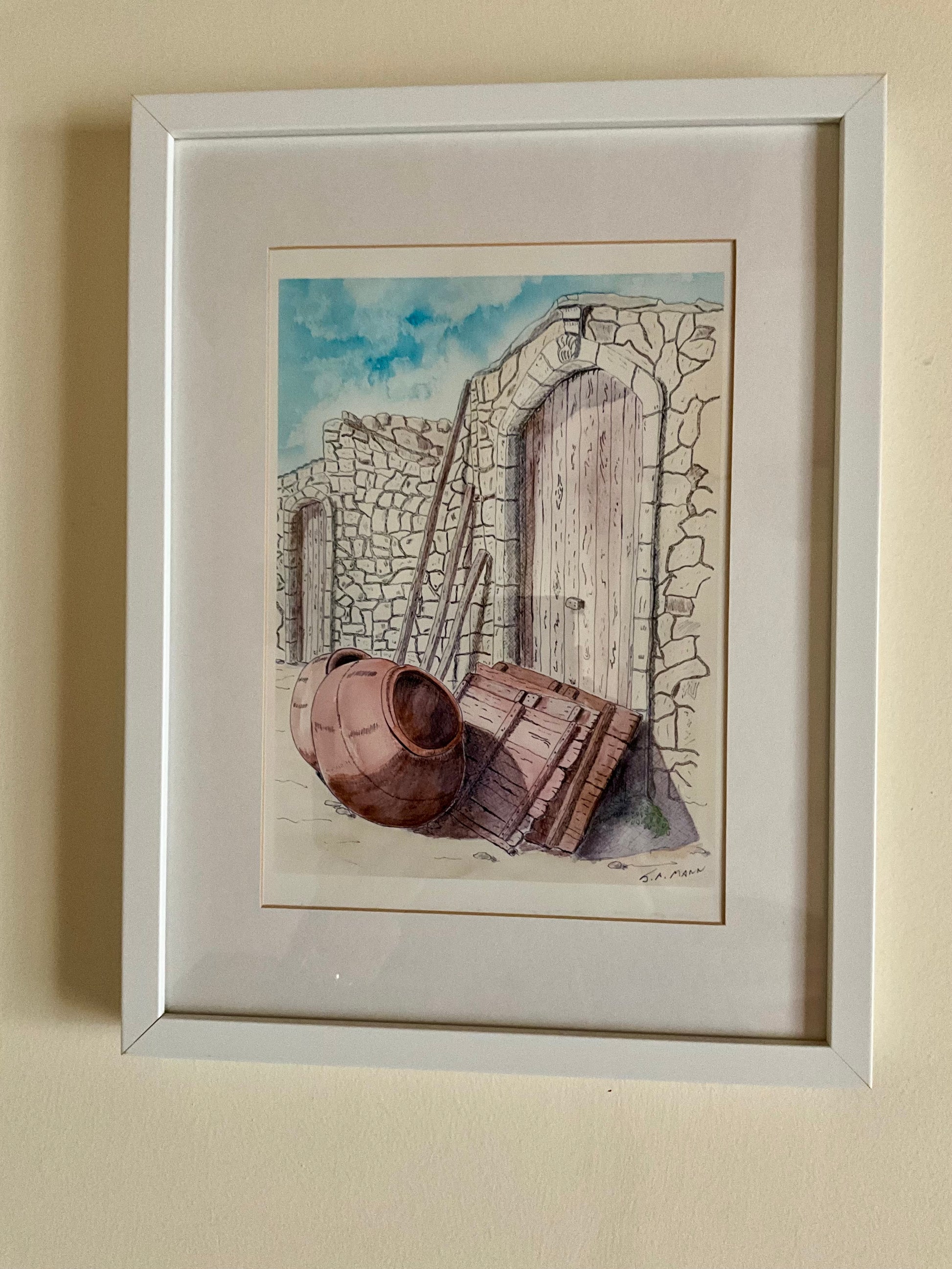 The Pithery pot and doors are a unique piece of decor, featuring a print of an original pen and wash drawing of old doors against a Cypriot village house. With its rustic charm and cultural significance, this piece will add character and style to any space. In a white box frame 16” x 12”