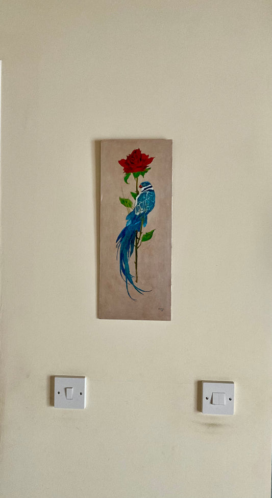 This original oil painting features a stunning blue bird of paradise gracefully perched on a vibrant red rose stem. The painting's dimensions, at 8" x 19", make it the perfect size for adding a touch of beauty to any room.