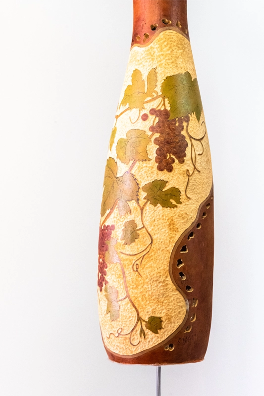 Gourd thunder drum, wood-burnt carved and finished in Wellburn inks with a picture of grape vines. 20” , 52cm tall