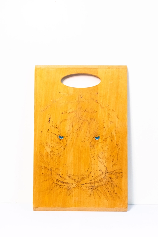 Beachwood chopping board woodburnt with Tigers head with fixed eyes. Finished in acrylic.  14” x 9”. 36cm x 23cm