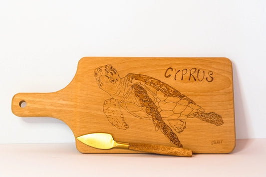 Beach wood cheese board. Wood-burnt with design of turtle and the word Cyprus. With attached cheese knife.