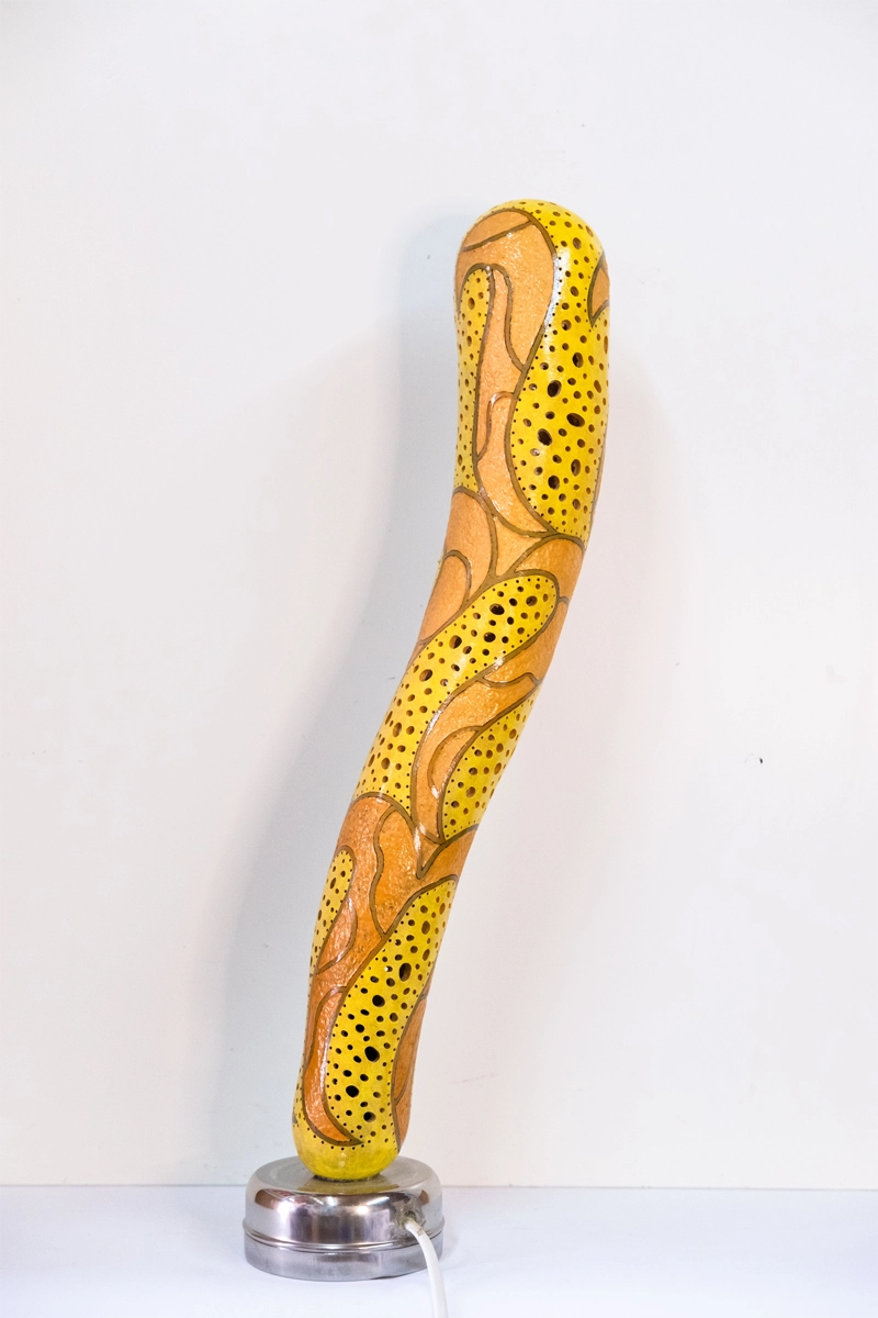 Gourd lamp, wood-burnt, carved and finished in acrylic on a metal base. Mains powered. 53cm tall