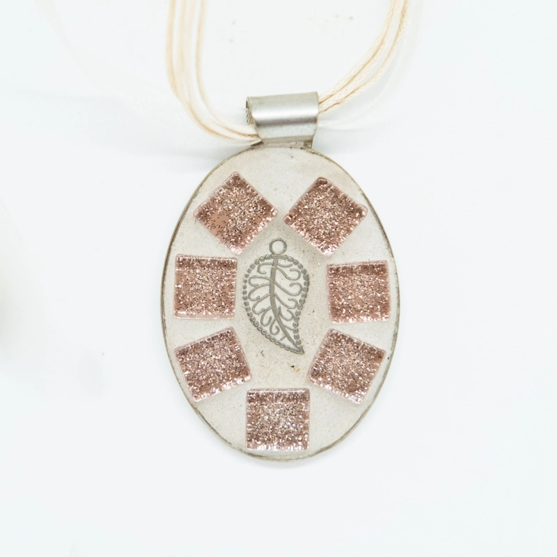 This pendant in delicate pink, with a silver leaf detail, exudes a subtle elegance in a charming and refined accessory.