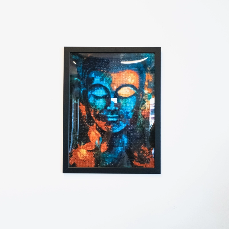 Beautiful eye-catching diamond painting of a Buddha in hues of blues, reds and orange.  Individually placed, faceted