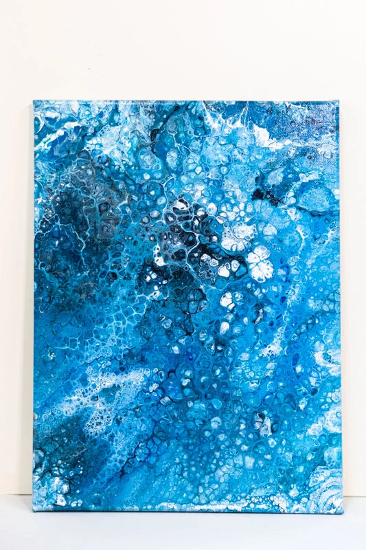 Acrylic pour painting using various shades of blues, aqua, black and white including holographic fine glitter.  Varnished with Matt varnish.