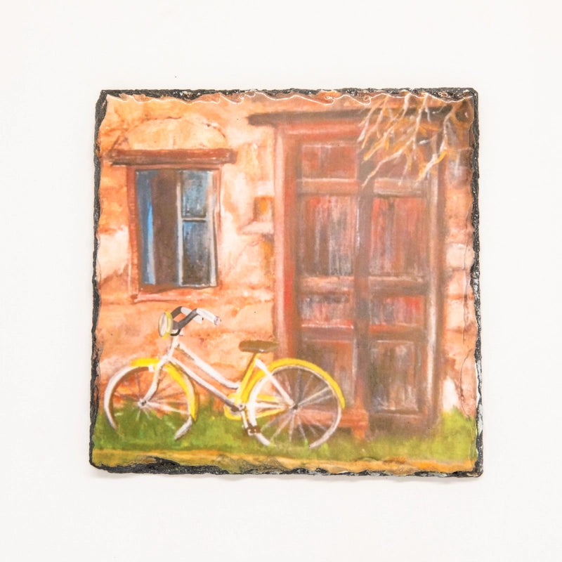 Printed on slate,yellow bike in front of old wooden door 